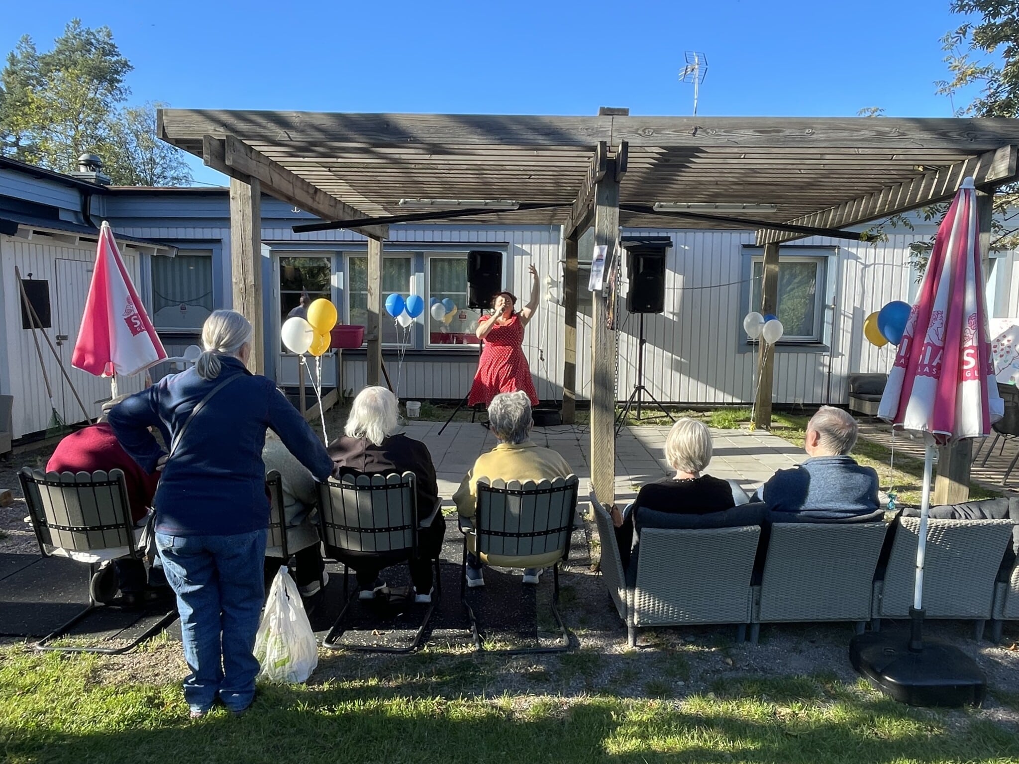 Sångerska uppträder framför en grupp äldre på Träffpunkten i Vallentuna